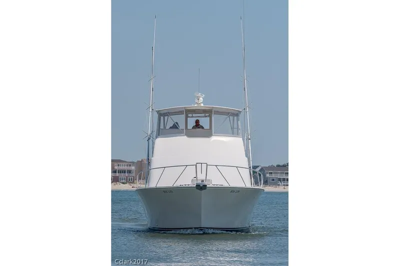 No Pressure Yacht Photos Pics Front view of a 2007 Post 53 Convertible boat on water, with coastal background.