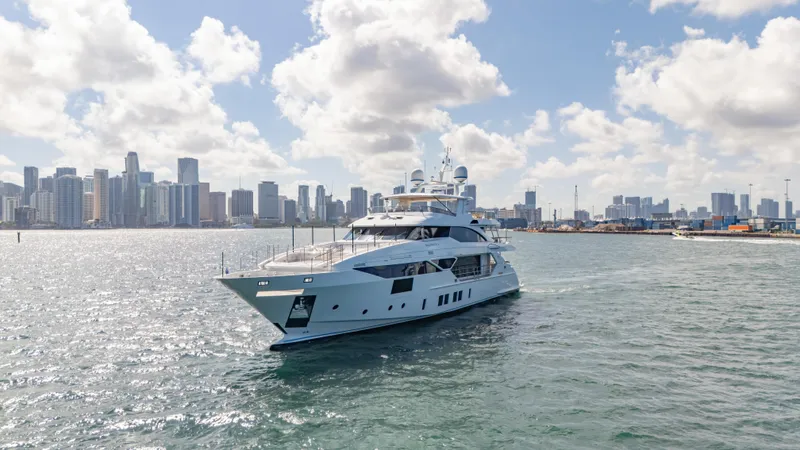 Inspiration Yacht Photos Pics Luxurious 2018 Benetti Fast 125 yacht cruising near a city skyline under a partly cloudy sky.