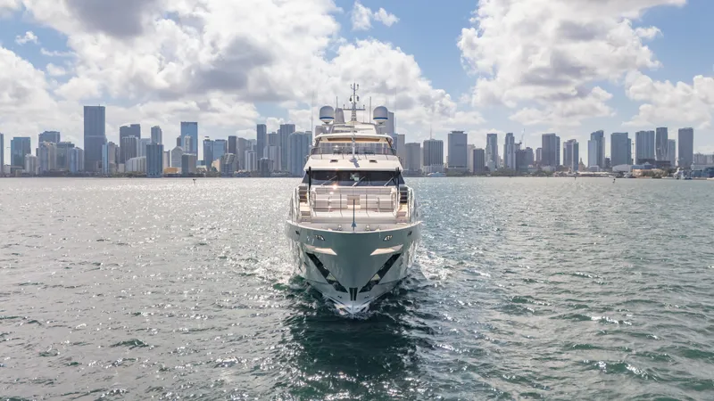 Inspiration Yacht Photos Pics Luxury Benetti Fast 125 yacht cruising near city skyline under cloudy sky.