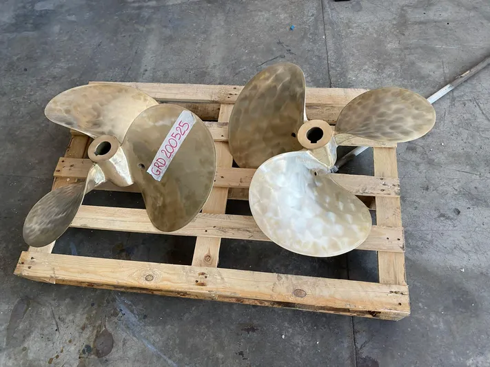  Yacht Photos Pics Two brass boat propellers on a wooden pallet, suitable for a 1989 Riva 51 Turborosso.
