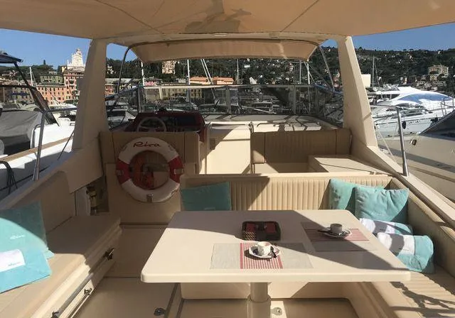  Yacht Photos Pics Luxurious 1989 Riva 51 Turborosso yacht interior with seating, table, and scenic marina view.