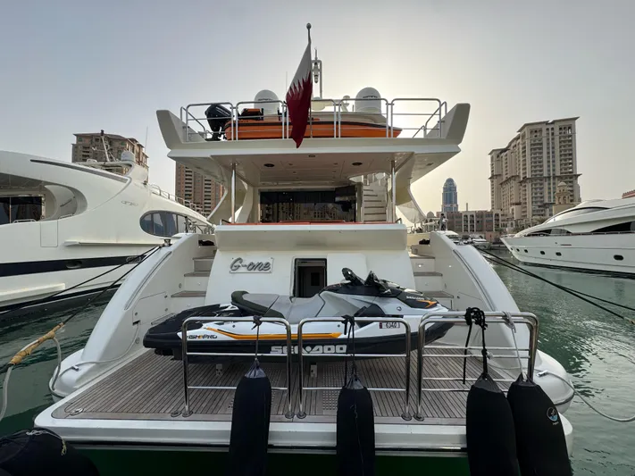 G-one Yacht Photos Pics 2009 Azimut 82 yacht docked, featuring a jet ski on the rear deck, cityscape in background.