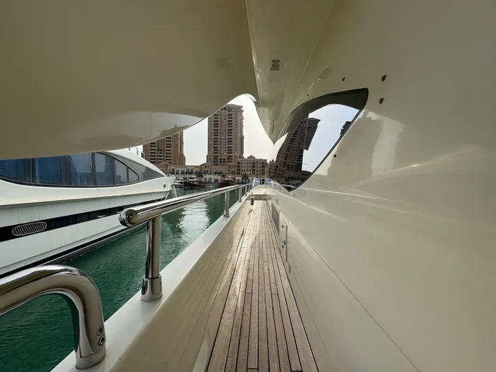 G-one Yacht Photos Pics Side deck view of 2009 Azimut 82 yacht with cityscape in background.