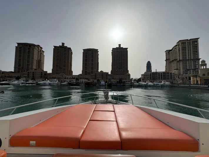 G-one Yacht Photos Pics Luxurious 2009 Azimut 82 yacht with orange deck, city skyline in background.