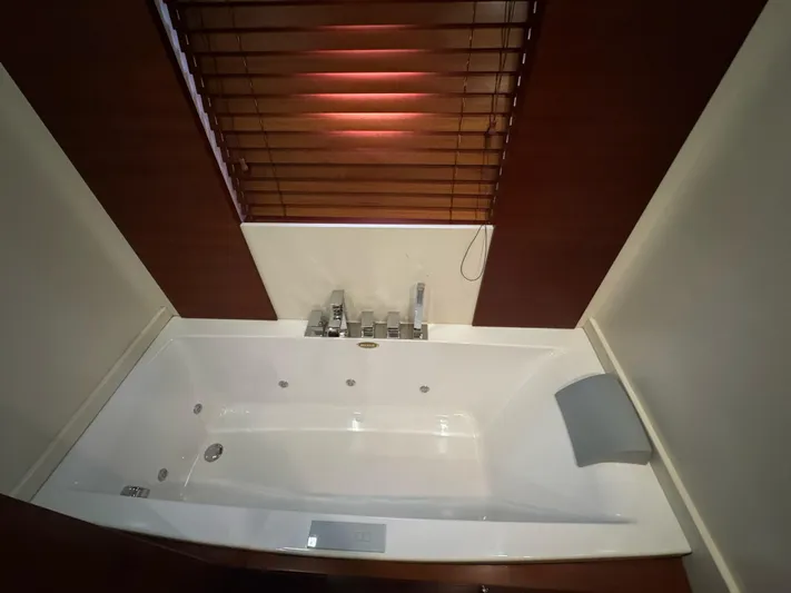 G-one Yacht Photos Pics Luxurious bathtub on 2009 Azimut 82 yacht with wooden blinds and modern fixtures.
