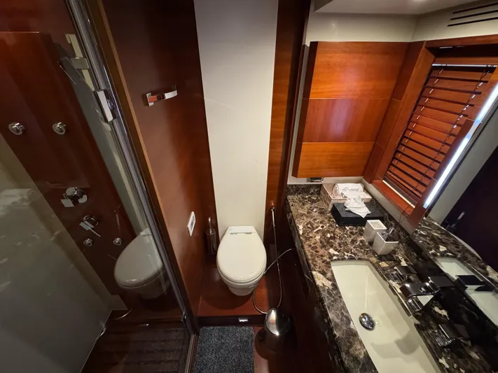 G-one Yacht Photos Pics Luxurious bathroom in 2009 Azimut 82 yacht with marble countertop and wooden accents.