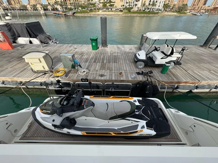 G-one Yacht Photos Pics Jet ski on Azimut 82 yacht, docked at marina with golf cart nearby, 2009 model.