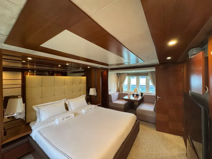 G-one Yacht Photos Pics Luxurious bedroom interior of 2009 Azimut 82 yacht with elegant wood finishes and cozy seating area.