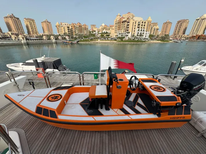 G-one Yacht Photos Pics Orange speedboat on Azimut 82 yacht, 2009, with waterfront cityscape in background.