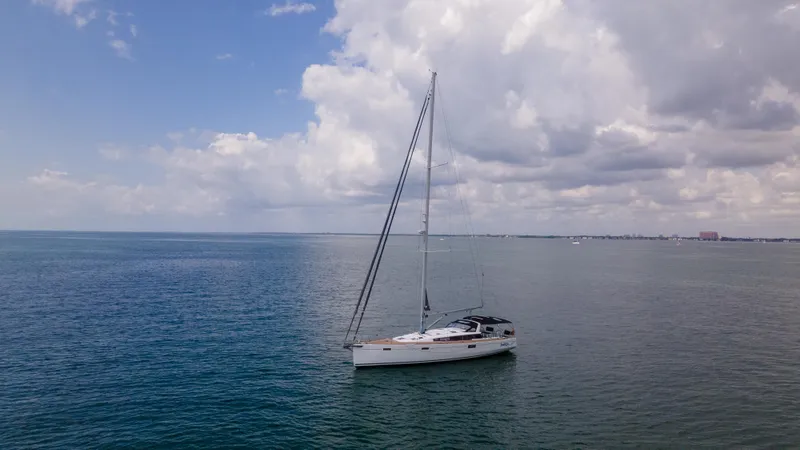 Indigo Dream Yacht Photos Pics Sailing yacht Beneteau Sense 50 (2012) on calm ocean under cloudy sky.