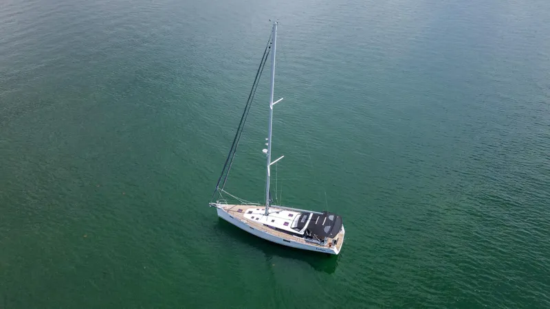 Indigo Dream Yacht Photos Pics Aerial view of 2012 Beneteau Sense 50 sailboat on calm green water.