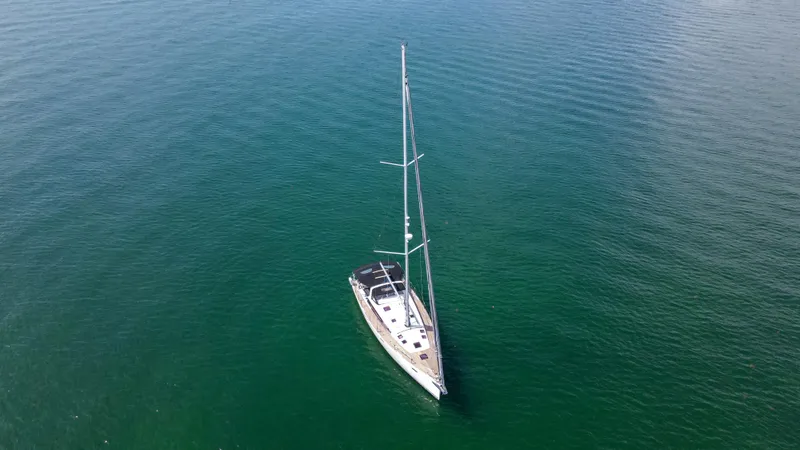 Indigo Dream Yacht Photos Pics Aerial view of 2012 Beneteau Sense 50 sailboat on calm green water.
