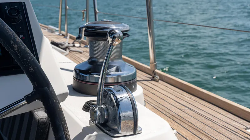 Indigo Dream Yacht Photos Pics 2012 Beneteau Sense 50 yacht deck with winch and steering wheel, sailing on open water.