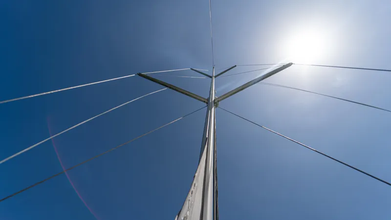 Indigo Dream Yacht Photos Pics Mast of 2012 Beneteau Sense 50 sailboat against clear blue sky and bright sun.