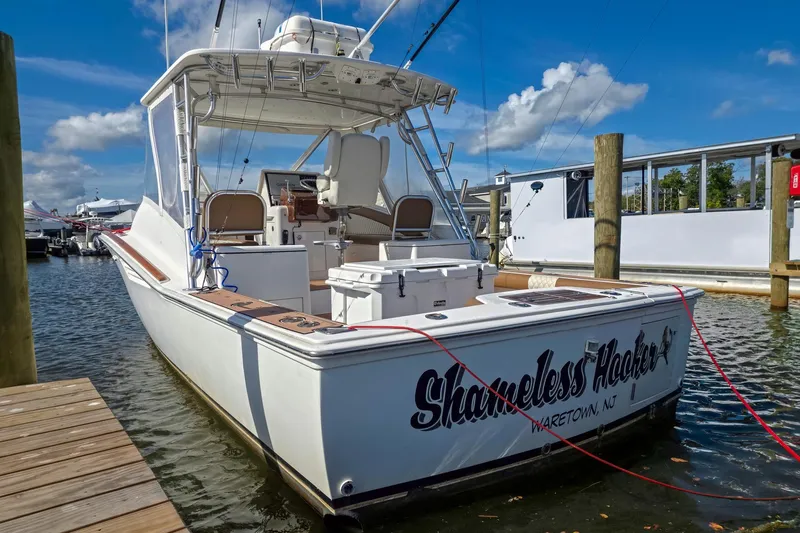  Yacht Photos Pics 2005 Egg Harbor 35' Express boat docked, featuring "Shameless Hooker" name, under a clear blue sky.