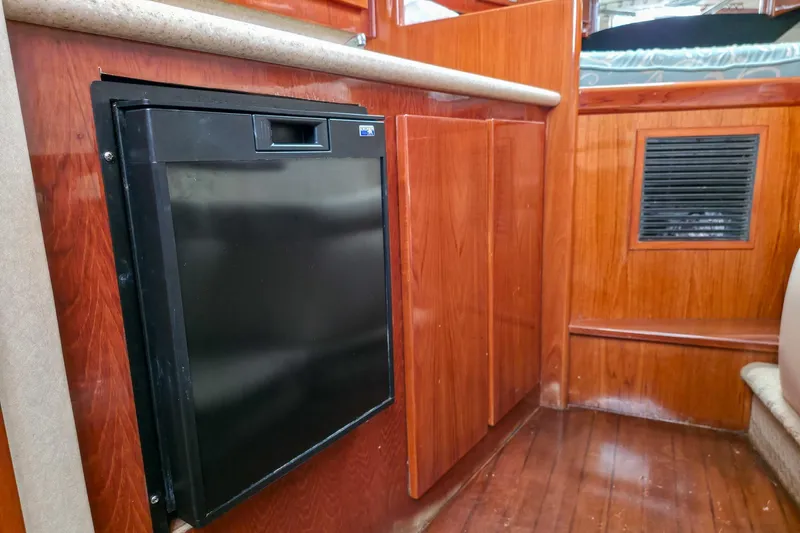  Yacht Photos Pics 2005 Egg Harbor 35' Express interior with wood paneling and compact black refrigerator.