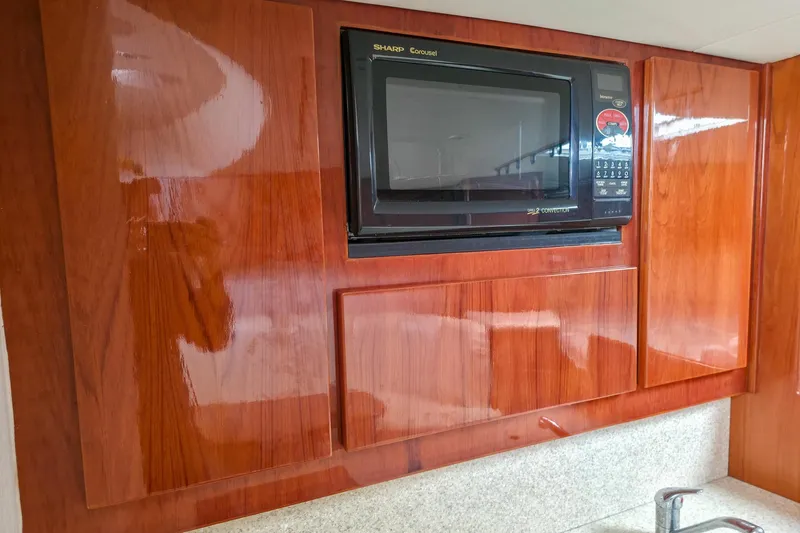  Yacht Photos Pics 2005 Egg Harbor 35' Express yacht kitchen with microwave and wooden cabinetry.