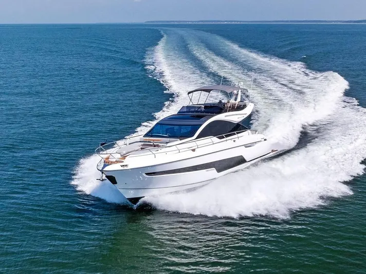  Yacht Photos Pics 2024 Fairline Phantom 65 yacht cruising on open water, creating a dynamic wake.