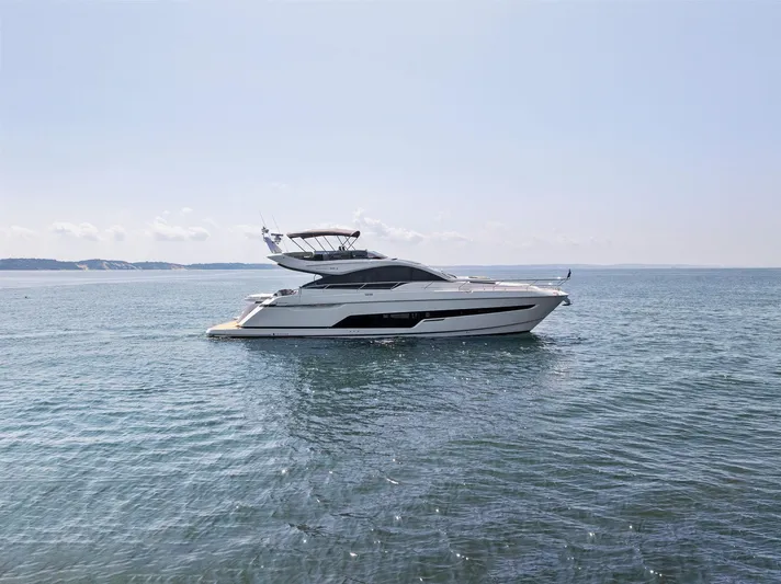  Yacht Photos Pics 2024 Fairline Phantom 65 yacht cruising on open water under clear skies.