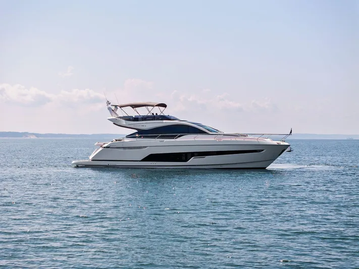  Yacht Photos Pics 2024 Fairline Phantom 65 yacht cruising on open water under a clear sky.