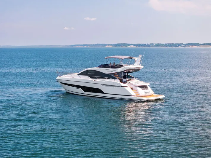  Yacht Photos Pics 2024 Fairline Phantom 65 yacht cruising on open water, clear sky in background.