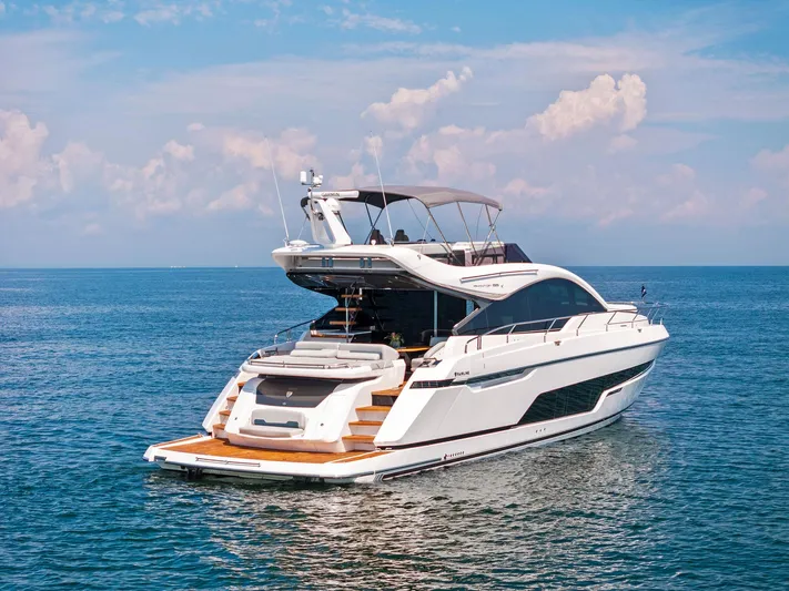  Yacht Photos Pics 2024 Fairline Phantom 65 yacht on calm ocean waters under a clear sky.