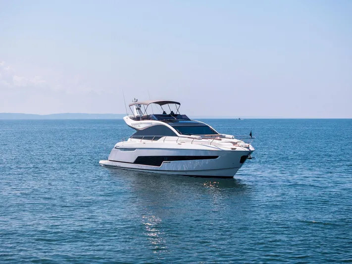  Yacht Photos Pics 2024 Fairline Phantom 65 yacht cruising on open sea under clear blue sky.