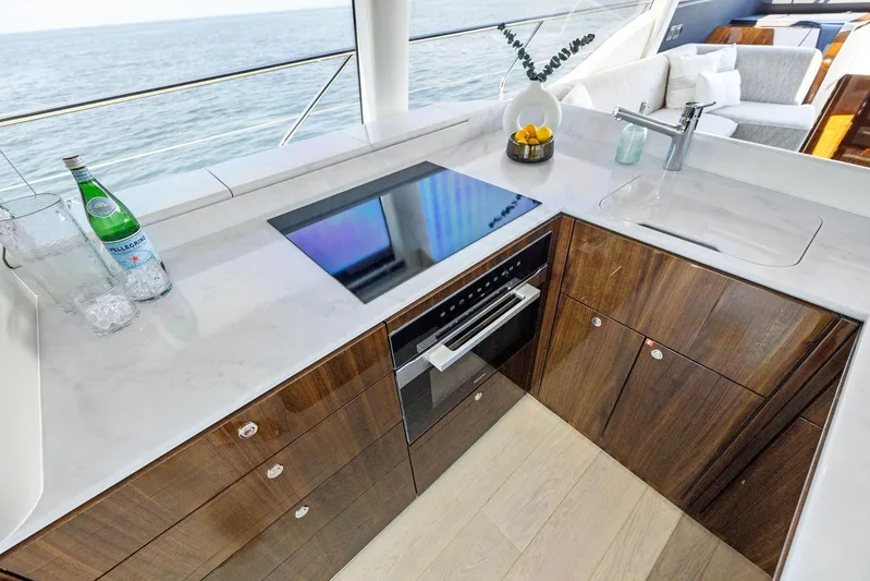  Yacht Photos Pics Modern kitchen on 2024 Fairline Phantom 65 yacht with ocean view, featuring sleek countertops and appliances.