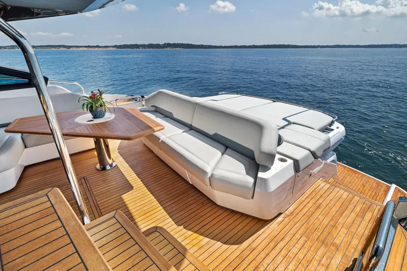  Yacht Photos Pics Luxurious 2024 Fairline Phantom 65 yacht deck with seating, table, and ocean view.