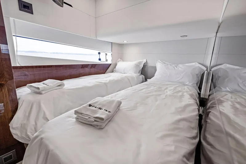  Yacht Photos Pics Luxurious twin cabin in 2024 Fairline Phantom 65 yacht, featuring elegant bedding and modern design.