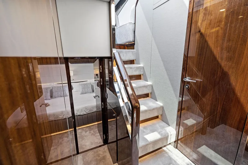  Yacht Photos Pics Luxurious interior of 2024 Fairline Phantom 65 yacht with elegant staircase and cozy bedroom.