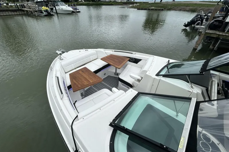  Yacht Photos Pics 2020 Sea Ray 350 SLX boat with white seating and wooden tables, docked in calm waters.