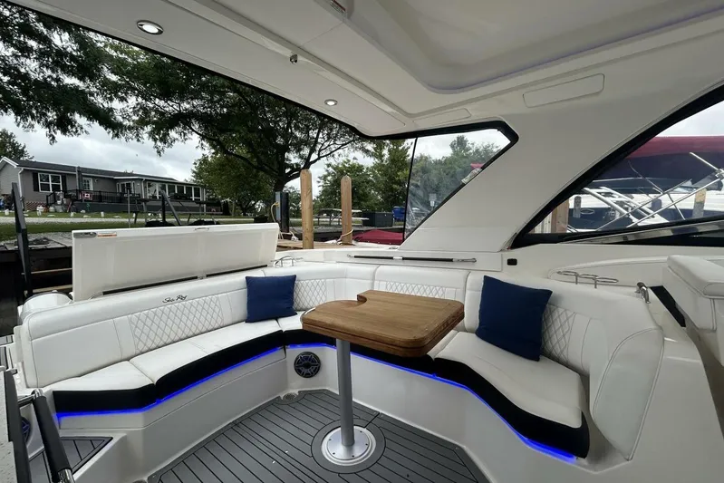  Yacht Photos Pics 2020 Sea Ray 350 SLX boat interior with white seating, wooden table, and blue accent lighting.