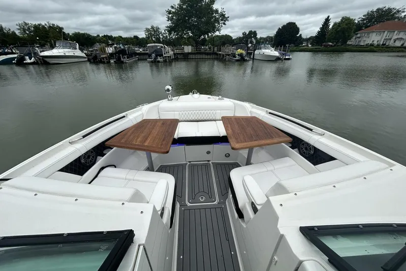  Yacht Photos Pics 2020 Sea Ray 350 SLX boat interior with wooden tables, docked on a calm lake.