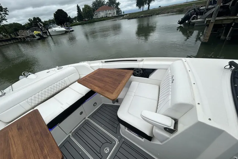  Yacht Photos Pics 2020 Sea Ray 350 SLX boat interior with white seating and wooden tables by a calm lake.