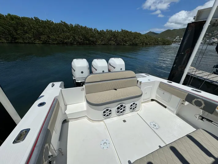  Yacht Photos Pics 2008 Fountain 38 TE boat with triple engines, docked near lush greenery and calm waters.