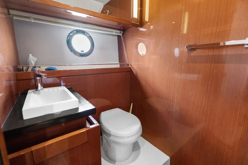 Dreamscape Yacht Photos Pics Luxurious bathroom in 2020 Beneteau Swift Trawler 50 with modern fixtures and wood paneling.