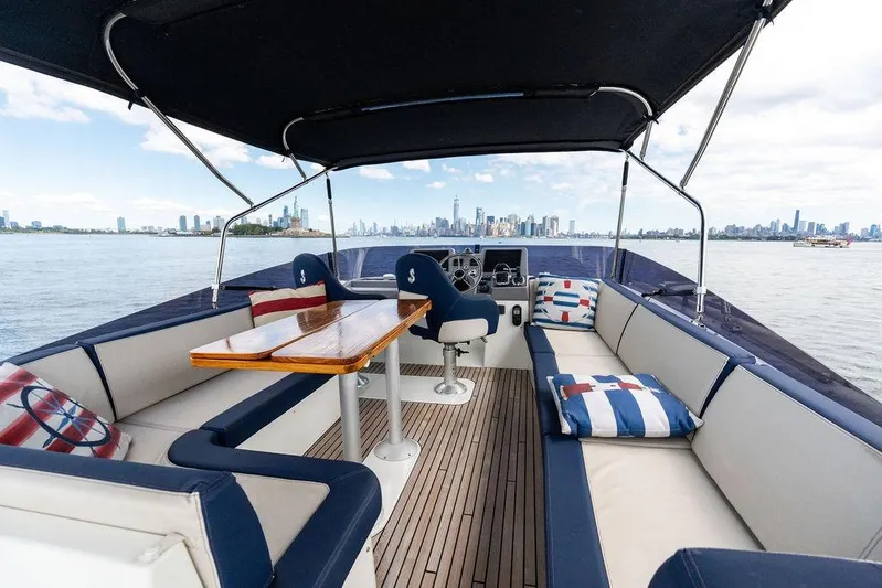 Dreamscape Yacht Photos Pics 2020 Beneteau Swift Trawler 50 flybridge with seating, table, and city skyline view.