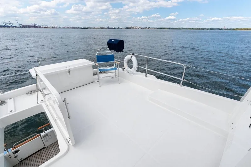 Dreamscape Yacht Photos Pics 2020 Beneteau Swift Trawler 50 deck with ocean view, featuring seating and safety equipment.