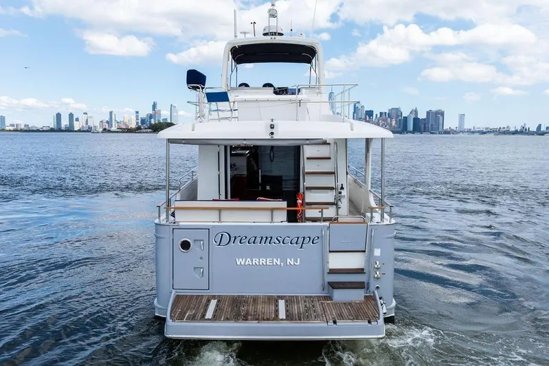 Dreamscape Yacht Photos Pics 2020 Beneteau Swift Trawler 50 named "Dreamscape" on water with city skyline.