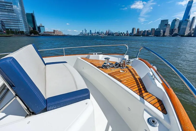 Dreamscape Yacht Photos Pics Beneteau Swift Trawler 50, 2020 model, cruising near city skyline on a sunny day.