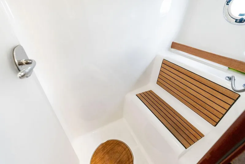 Dreamscape Yacht Photos Pics 2020 Beneteau Swift Trawler 50 interior with wooden seating and porthole.