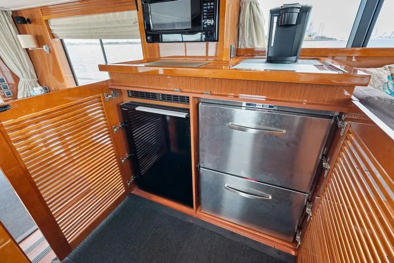 Dreamscape Yacht Photos Pics 2020 Beneteau Swift Trawler 50 kitchen with stainless steel appliances and wooden cabinetry.