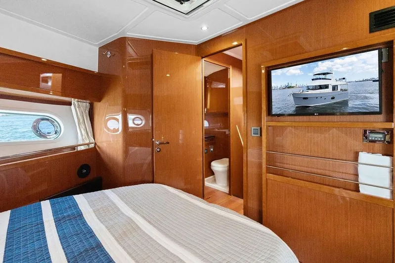 Dreamscape Yacht Photos Pics Luxurious cabin interior of 2020 Beneteau Swift Trawler 50 with wood finish and porthole view.