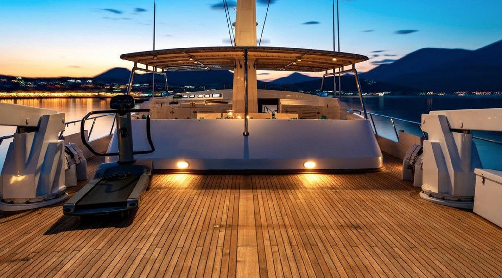 Luxurious 1987 Codecasa yacht deck at sunset, featuring elegant wooden flooring.