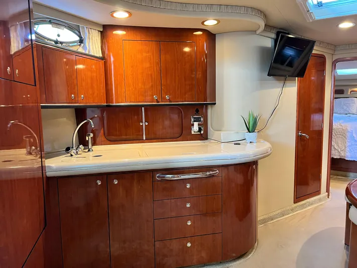  Yacht Photos Pics Luxurious interior of 2003 Sea Ray 460 Sundancer yacht with elegant wood cabinetry and modern amenities.