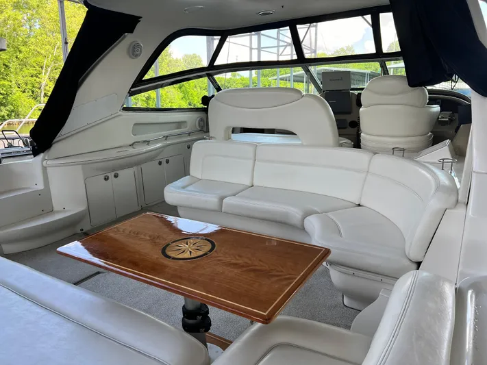  Yacht Photos Pics Interior of 2003 Sea Ray 460 Sundancer yacht with white seating and wooden table.