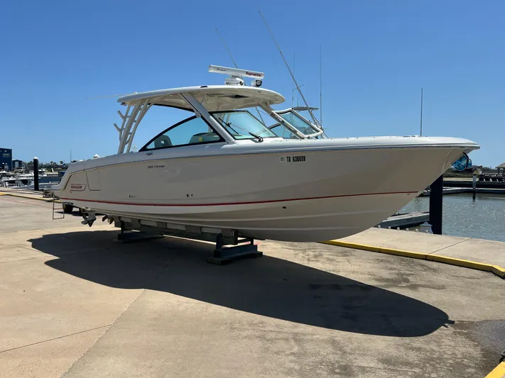  Yacht Photos Pics 2017 Boston Whaler 320 Vantage boat on a dock under clear blue sky.