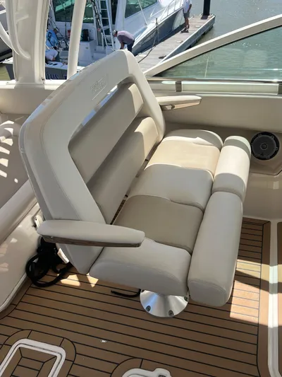  Yacht Photos Pics 2017 Boston Whaler 320 Vantage boat seat with beige upholstery and wooden deck.