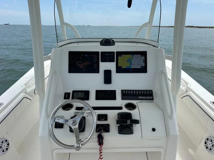  Yacht Photos Pics 2016 Regulator center console boat dashboard with navigation screens and steering wheel on open water.